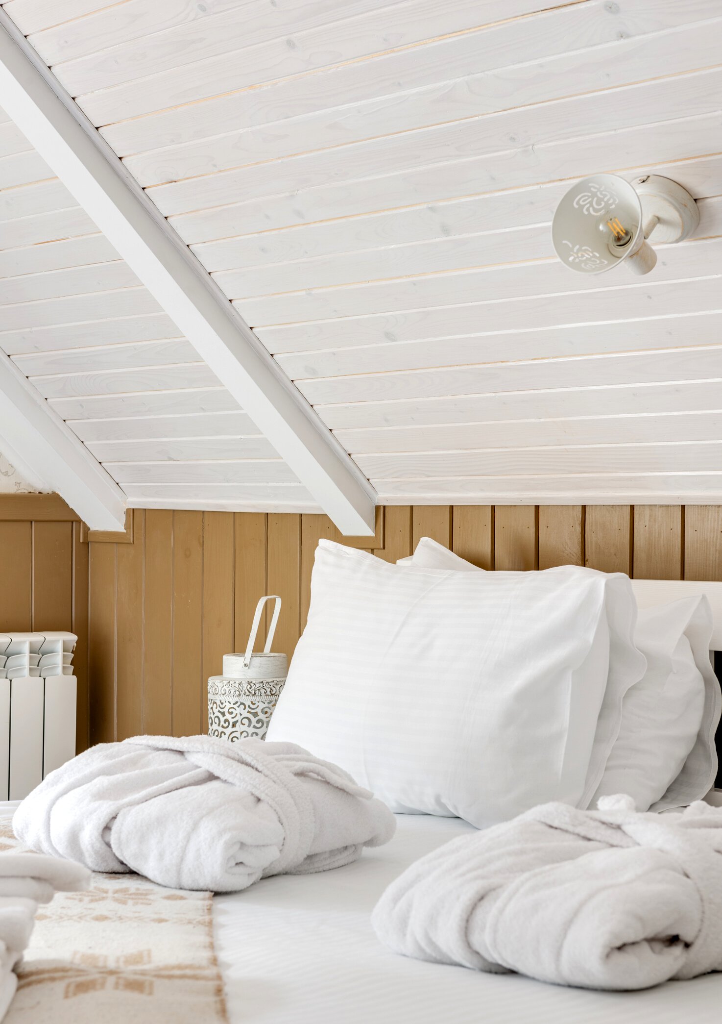 Dressing Gowns Folded on a Bed with White Sheets in a Hotel Room 